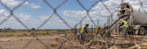 Vaciado de concreto visto a través de una cerca de obra